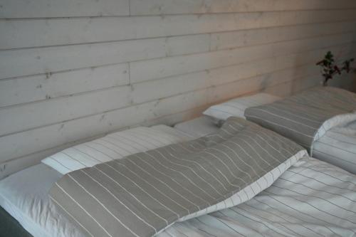 LumijokiWilla Rauha G的墙上的房间里设有三张白色的床
