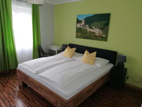 斯皮茨Gästehaus Ruinenblick的卧室配有一张带黄色枕头的大型白色床。