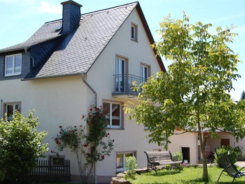 曼德沙伊德Comfortable holiday home Manderscheid with garden的前面有长凳的白色房子