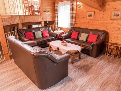 洛斯堡施罗德度假屋的客厅配有两张真皮沙发和一张桌子