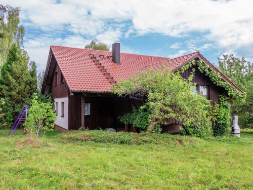 洛斯堡施罗德度假屋的绿色田野上一座红色屋顶的房子