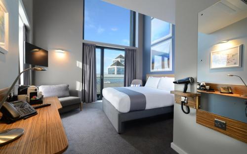 都柏林Travelodge PLUS Dublin City Centre的配有一张床和一张书桌的酒店客房