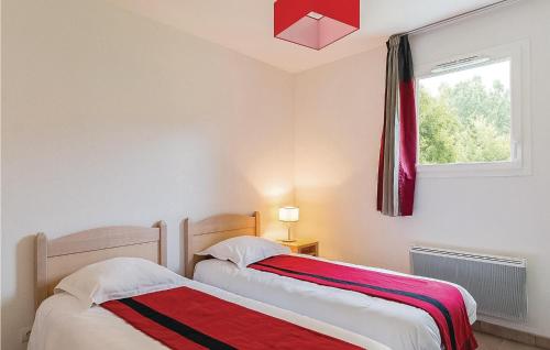 蒙蒂尼亚克Les Bastides De Lascaux的卧室设有两张床,带窗户