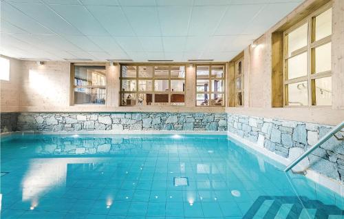 莱热Les Fermes miguy的大楼内一个蓝色的大型游泳池