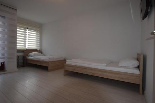 魏布林根AB Apartment Waiblingen的客房设有两张床和窗户。