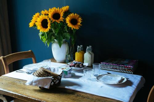 纽南梵高屋住宿加早餐旅馆的一张桌子,上面有花瓶,上面有向日葵