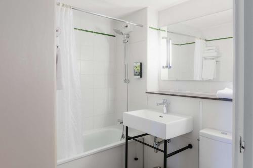 勒庞克涅特Sure Hotel by Best Western Châteauroux的白色的浴室设有水槽和淋浴。