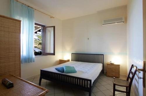库斯托纳奇Villa Levante vista mare Cornino的一间卧室设有一张床、一个窗口和一把椅子
