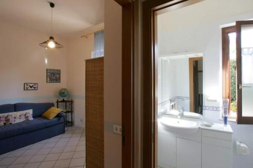 库斯托纳奇Villa Levante vista mare Cornino的一间带水槽和蓝色沙发的浴室