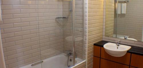 道宁斯唐宁海湾酒店的带浴缸、水槽和淋浴的浴室
