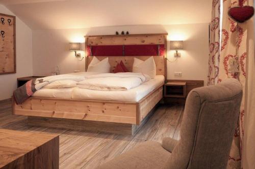 普夫龙滕Pension Alpenblick的一间卧室配有一张大床和木制床头板
