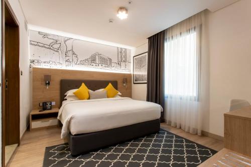 阿可贺巴Cindyan Apartments by The Quarter的酒店客房配有一张带黄色枕头的大床