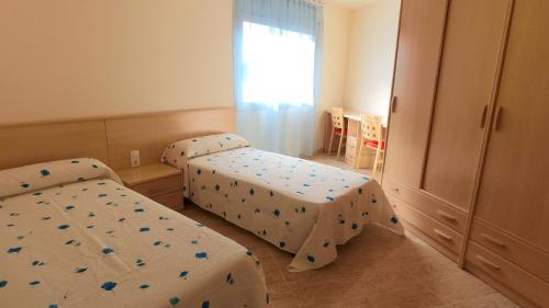 卡拉法特Apartamento con Espectaculares Vistas al Mar (Llobeta 3A)的一间卧室设有两张床和窗户。