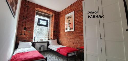 彼得库夫特雷布纳尔斯基Cosy Rooms的一间设有两张床和砖墙的房间