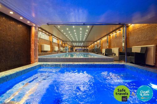 诺维萨德普利兹登特贝斯特韦斯特酒店的大楼内一个蓝色的大型游泳池
