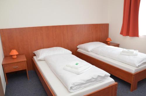 胡斯托佩切鲁泽尼酒店的配有2张床的客房内配有白色床单和毛巾