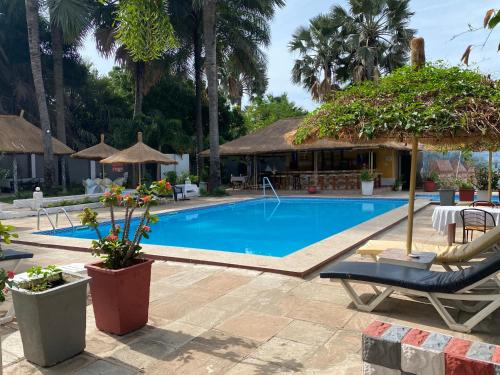 科图卡拉巴斯公寓式酒店的度假村的游泳池配有椅子和遮阳伞