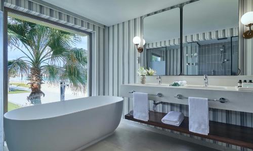 阿莱曼Al Alamein Hotel的一间带大浴缸和大窗户的浴室