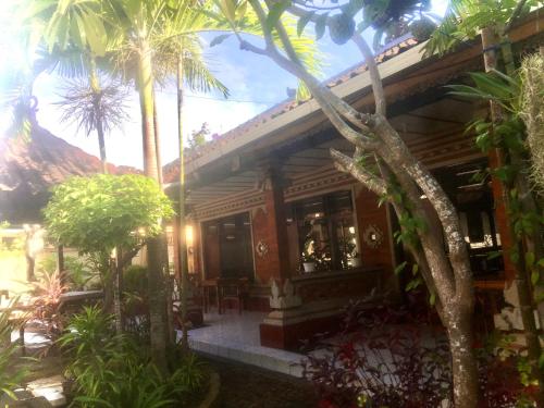 沙努尔莱斯塔利酒店的前面有棕榈树的房子