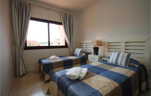 米哈斯科斯塔马贝拉罗萨里奥公寓的一间卧室设有两张床和窗户。