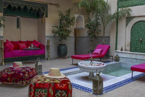 马拉喀什Riad Dar Habiba by Garden Wonders的客厅配有粉色家具和喷泉