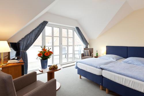 瓦伦英格堡酒店的一间卧室设有蓝色的床和大窗户