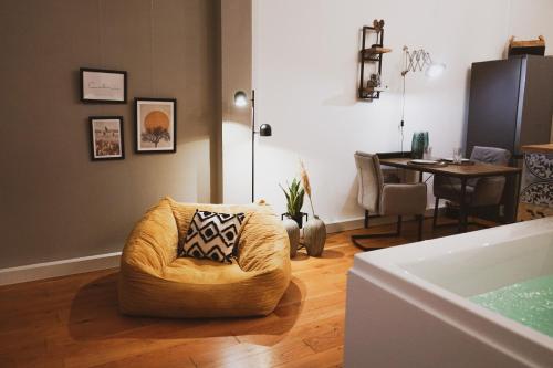 特里尔Stilvolles City-Loft mit privatem Whirlpool的客厅配有椅子和桌子