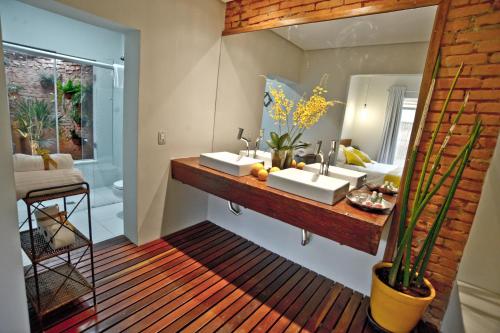 雅库廷加Pousada e Restaurante Caminhos do Bom Café的浴室设有2个水槽和镜子