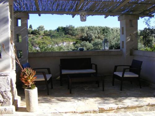 法萨诺Masseria Pelosella B&B的庭院配有桌椅和窗户。
