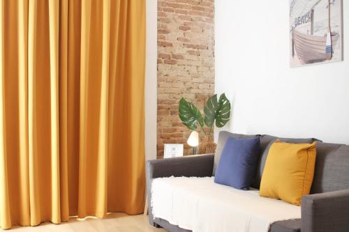 塔拉戈纳Mediterranean Way - Tarragona Central Apartments的客厅设有黄色窗帘的沙发