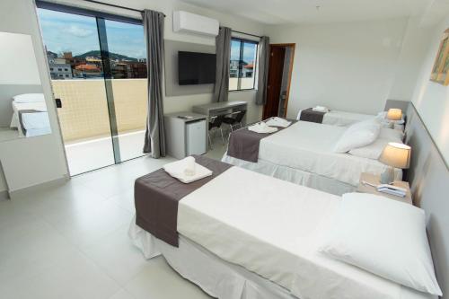 卡波布里奥Hotel Mirante do Forte的酒店客房设有两张床和电视。