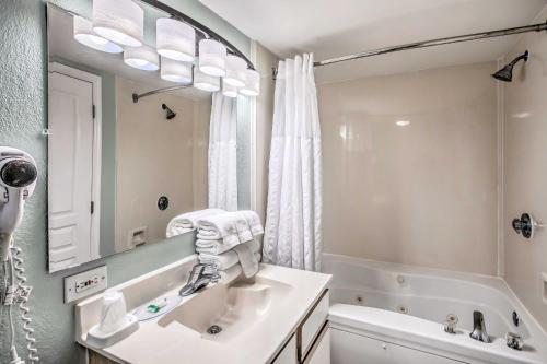 默特尔比奇Oceanfront N Myrtle Beach Condo with Hot Tub!的浴室配有盥洗盆、镜子和浴缸