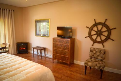 尤克卢利特海雾住宿加早餐旅馆的一间卧室设有一张床、一台电视和墙上的轮子