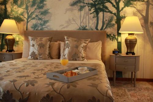 乔卢拉Santo Refugio Heritage Hotel的一张带食物托盘和香槟的床铺