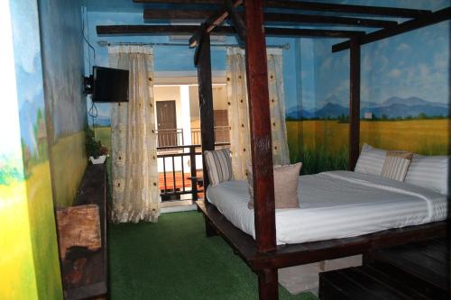 清莱温灿迪酒店的一间卧室设有一张床,阳台配有电视。