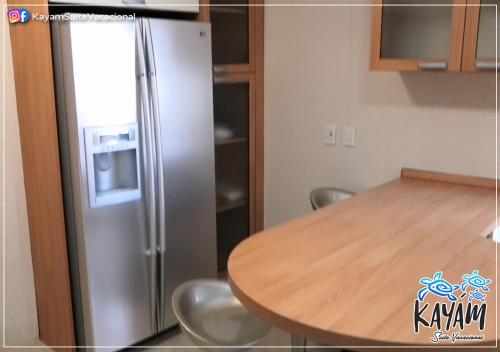 韦拉克鲁斯KAYÁM Suite Vacacional的厨房配有不锈钢冰箱和桌子