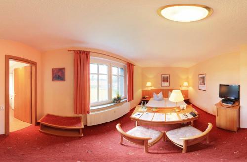 施莱茨Hotel Luginsland的客厅配有桌子和窗户