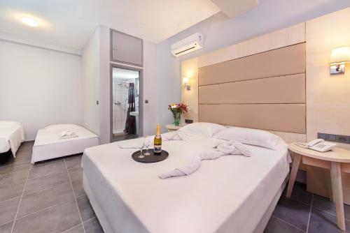 科林比亚Villa Mare by Delfinia Resort的酒店客房,配有一张带一瓶香槟的床