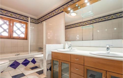 里乌德洛茨·德拉塞尔8 Bedroom Amazing Home In Riudellots的一间带两个盥洗盆和卫生间的浴室