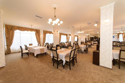 阿拉德Hotel Miky的一间设有白色桌椅的用餐室
