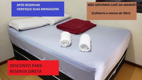约恩维利Recanto Boa Vista的一张带两条毛巾和红色盒子的床
