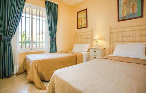 马贝拉埃尔维利亚02公寓的一间卧室设有两张床和窗户。