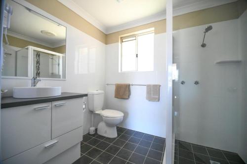 WarrenMacquarie Valley Motor Inn的浴室配有卫生间、盥洗盆和淋浴。