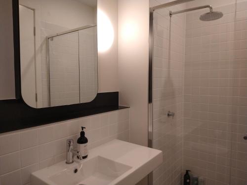 PhillipBrand New Spacious Woden Apartment - KingBed&WiFi的白色的浴室设有水槽和淋浴。