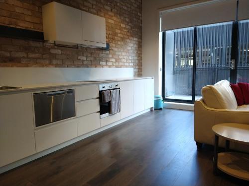 PhillipBrand New Spacious Woden Apartment - KingBed&WiFi的一间带炉灶的厨房和一张沙发