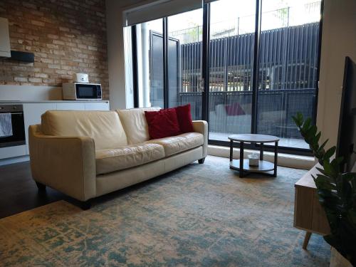 PhillipBrand New Spacious Woden Apartment - KingBed&WiFi的客厅配有沙发和桌子