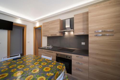巴多尼奇亚泰伯公寓式酒店的一个带木制橱柜的厨房和一张位于客房内的床