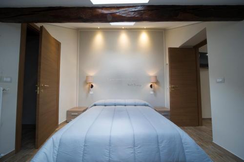 巴多尼奇亚泰伯公寓式酒店的一张大床,墙上有两盏灯