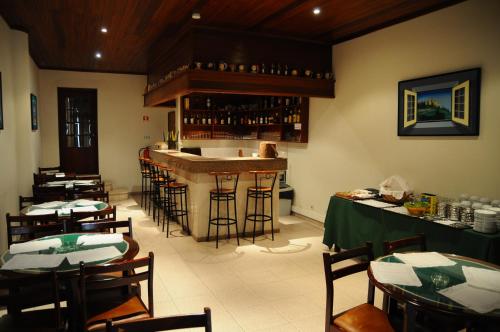 萨尔堡Hotel A Cegonha的餐厅设有酒吧,配有桌椅