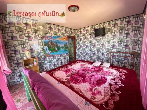 Ban Maeo Thap Boekไร่รุ่งอรุณ ภูทับเบิก的一间卧室,床上有粉红色的鲜花